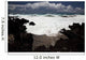 A wave breaks with lave rocks in the foreground Wall Mural