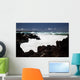 A wave breaks with lave rocks in the foreground Wall Mural