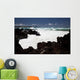 A wave breaks with lave rocks in the foreground Wall Mural
