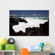 A wave breaks with lave rocks in the foreground Wall Mural