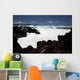 A wave breaks with lave rocks in the foreground Wall Mural