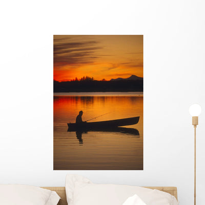 Man Canoeing Sunset Lake Wall Mural shown on a wall