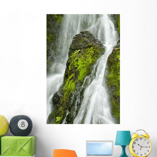 Waterfall Flows Over Green Foliage And Rock Outcrop Wall Mural