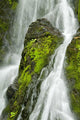 Waterfall Flows Over Green Foliage And Rock Outcrop Wall Mural
