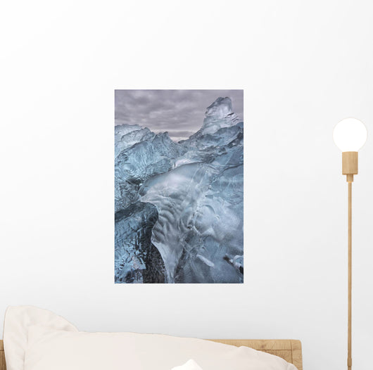 A close-up view of glacial ice strewn across a coastal beach Wall Mural
