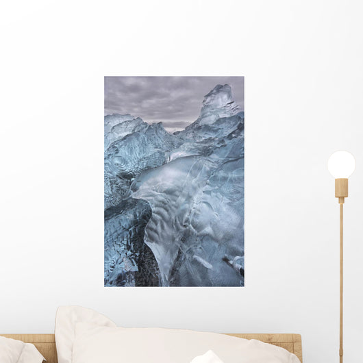 A close-up view of glacial ice strewn across a coastal beach Wall Mural
