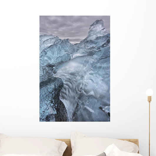 A close-up view of glacial ice strewn across a coastal beach Wall Mural