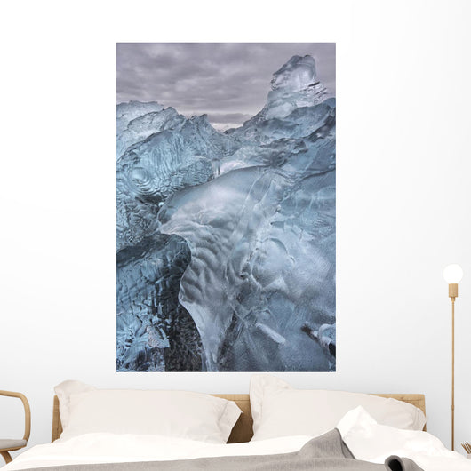 A close-up view of glacial ice strewn across a coastal beach Wall Mural