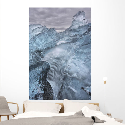 A close-up view of glacial ice strewn across a coastal beach Wall Mural
