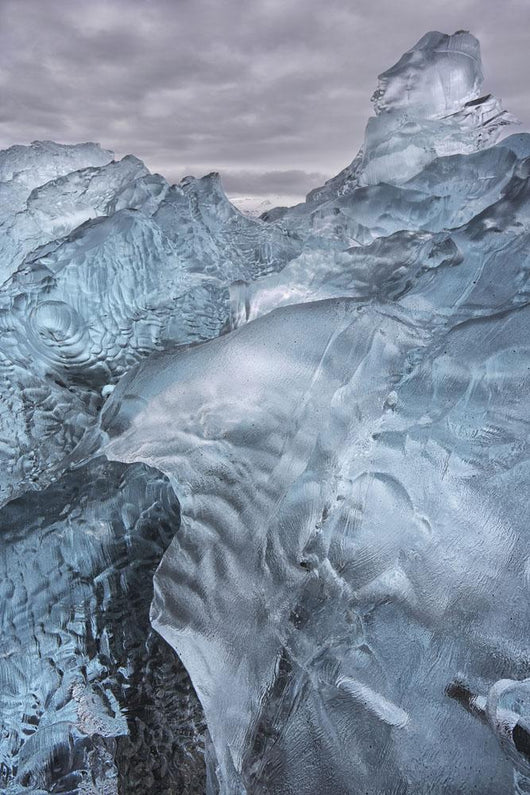 A close-up view of glacial ice strewn across a coastal beach Wall Mural