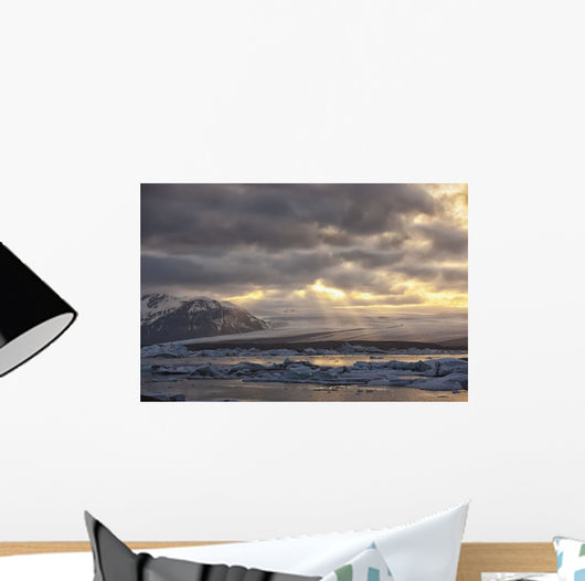 Shafts of sunlight shine on the ice calves floating Wall Mural