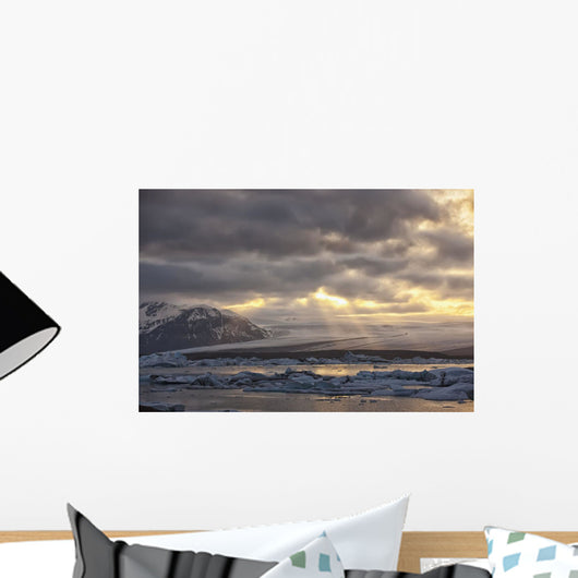 Shafts of sunlight shine on the ice calves floating Wall Mural