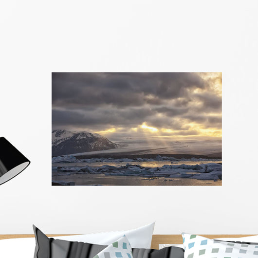 Shafts of sunlight shine on the ice calves floating Wall Mural