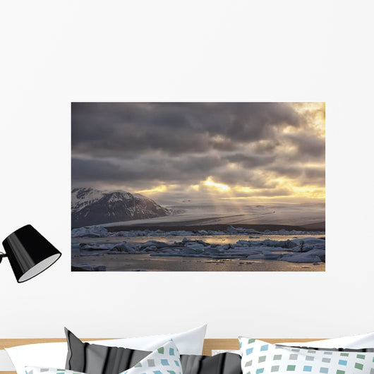 Shafts of sunlight shine on the ice calves floating Wall Mural