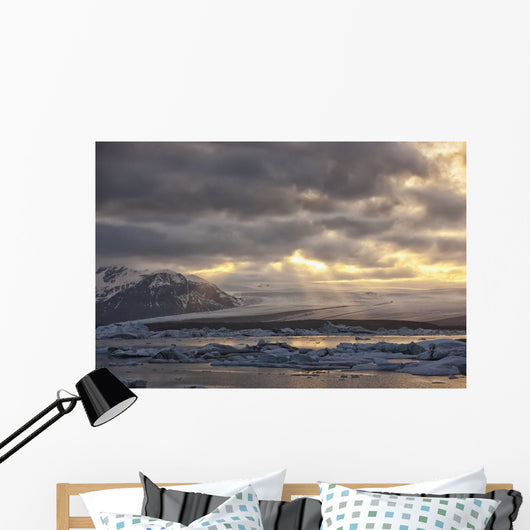 Shafts of sunlight shine on the ice calves floating Wall Mural