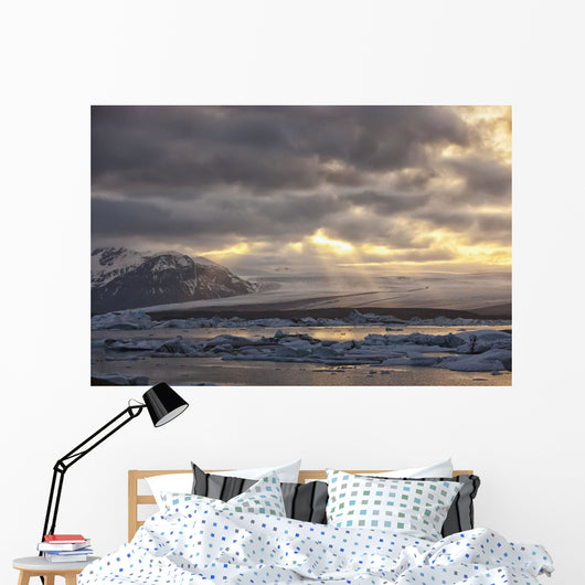 Shafts of sunlight shine on the ice calves floating Wall Mural