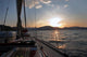 Sailing boat in the sea at sunset Wall Mural