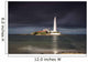 White Lighthouse Illuminated By Sunlight Under A Dark Stormy Sky Wall Mural