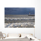 Storm waves crashing on a beach near a lighthouse on lake ontario Wall Mural