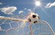 Soccer ball in the net on the sky background Wall Mural