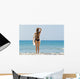 A woman wearing a black bikini stands Wall Mural