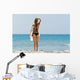 A woman wearing a black bikini stands Wall Mural