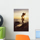 Silhouette of a woman standing on a rock Wall Mural