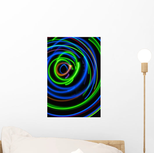 Silhouette of woman spinning hula-hoop lit with LEDs in field at night Wall Mural