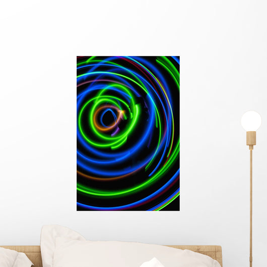 Silhouette of woman spinning hula-hoop lit with LEDs in field at night Wall Mural