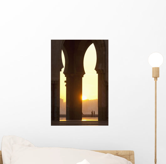 Morocco, Looking through arches of Hassan II mosque to couple chatting Wall Mural