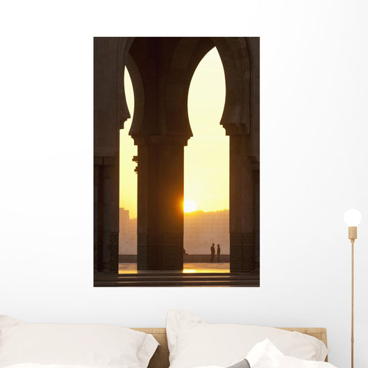 Morocco, Looking through arches of Hassan II mosque to couple chatting Wall Mural