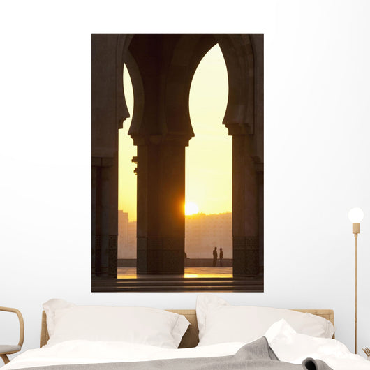 Morocco, Looking through arches of Hassan II mosque to couple chatting Wall Mural