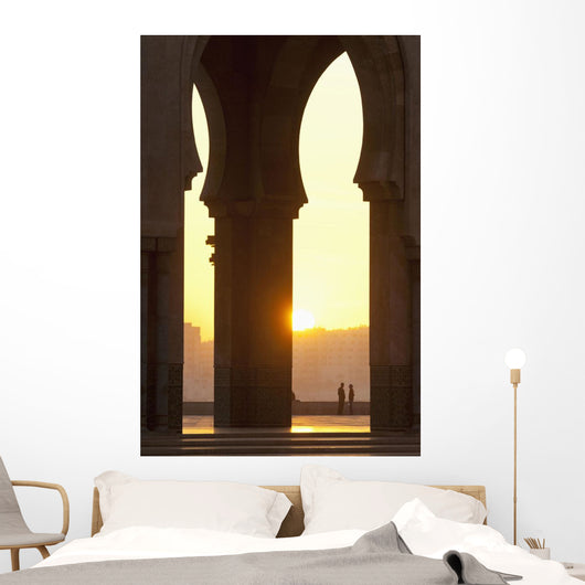Morocco, Looking through arches of Hassan II mosque to couple chatting Wall Mural