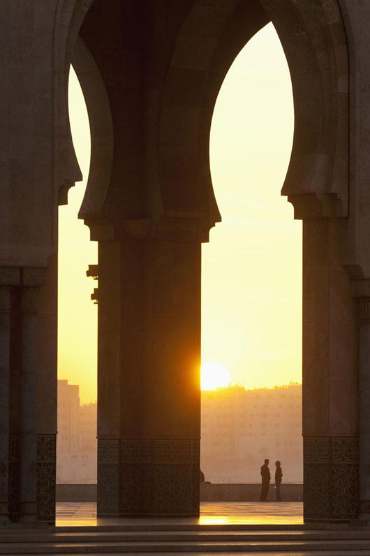Morocco, Looking through arches of Hassan II mosque to couple chatting Wall Mural
