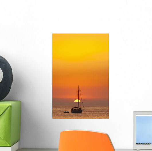 Spain, People watching sunset from yacht moored off Benirras beach Wall Mural