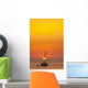 Spain, People watching sunset from yacht moored off Benirras beach Wall Mural