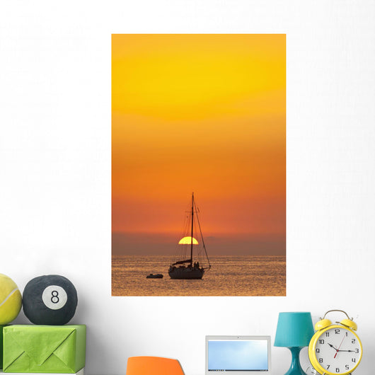 Spain, People watching sunset from yacht moored off Benirras beach Wall Mural