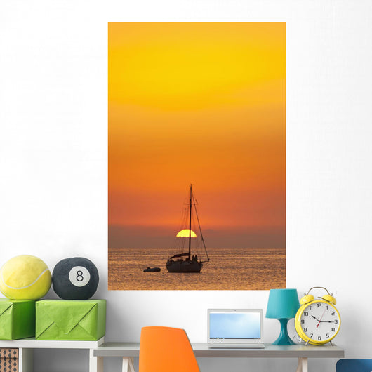 Spain, People watching sunset from yacht moored off Benirras beach Wall Mural