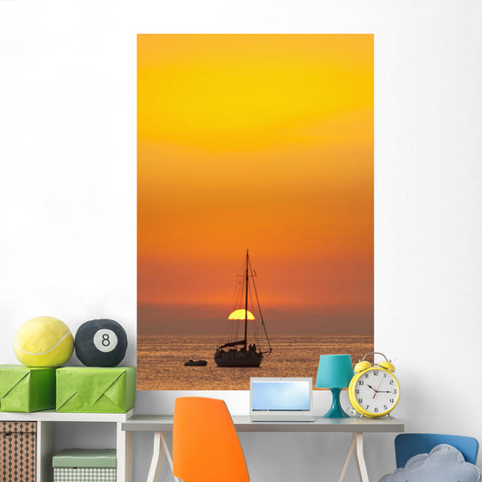Spain, People watching sunset from yacht moored off Benirras beach Wall Mural