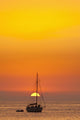 Spain, People watching sunset from yacht moored off Benirras beach Wall Mural