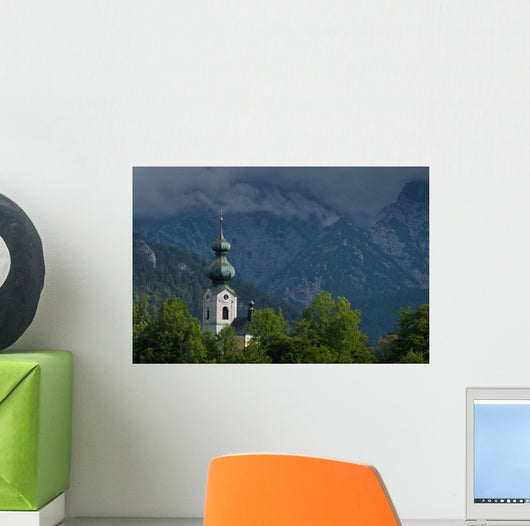 Germany, Stormy clouds behind Ruhpolding church Wall Mural