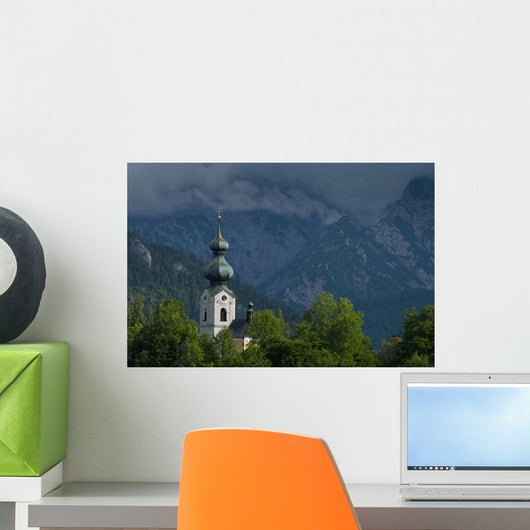 Germany, Stormy clouds behind Ruhpolding church Wall Mural
