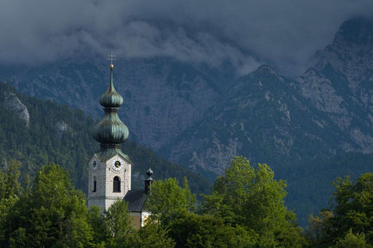 Germany, Stormy clouds behind Ruhpolding church Wall Mural