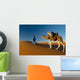 Berber leading camel across sand dune near Merzouga in Sahara Desert Wall Mural
