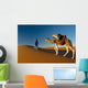 Berber leading camel across sand dune near Merzouga in Sahara Desert Wall Mural