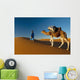 Berber leading camel across sand dune near Merzouga in Sahara Desert Wall Mural