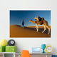 Berber leading camel across sand dune near Merzouga in Sahara Desert Wall Mural