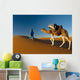 Berber leading camel across sand dune near Merzouga in Sahara Desert Wall Mural