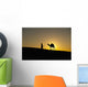 Silhouette of Berber 'Blue man' leading camel across sand dunes Wall Mural