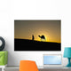Silhouette of Berber 'Blue man' leading camel across sand dunes Wall Mural
